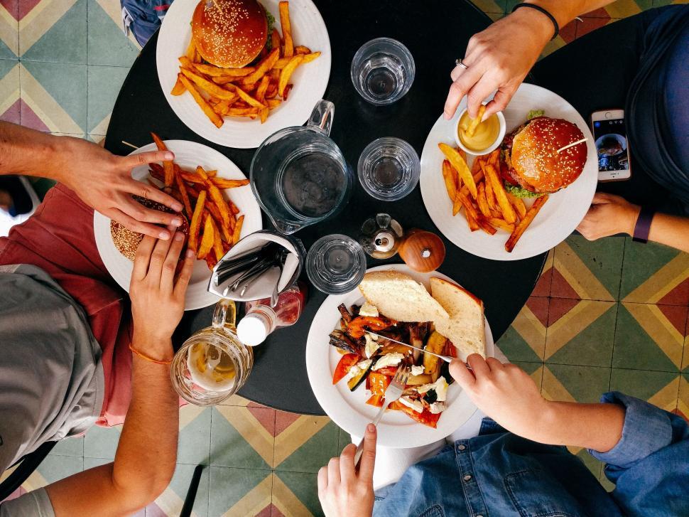 A person sitting at a table with a colorful bowl of food, eating attentively without distractions